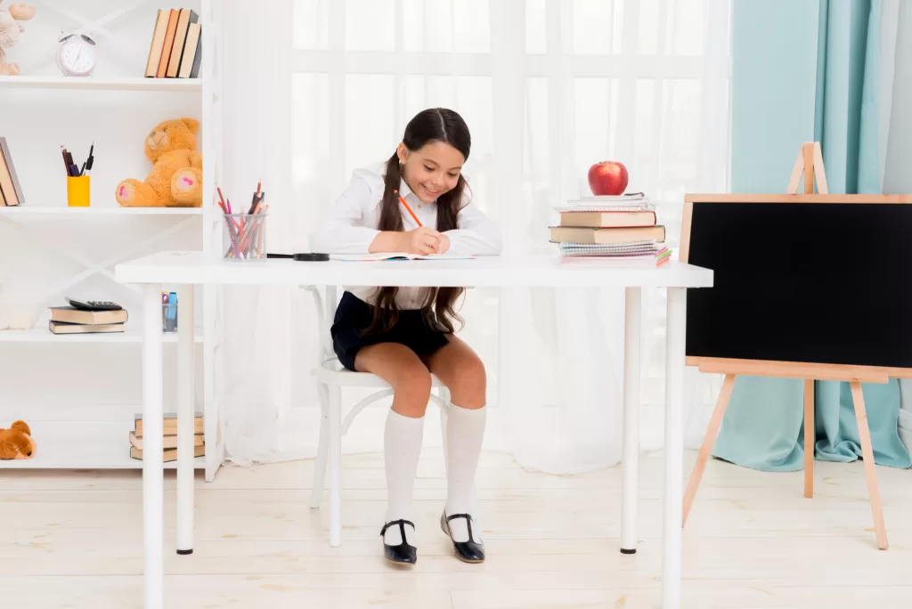 Cute School Girl Sitting on Desk